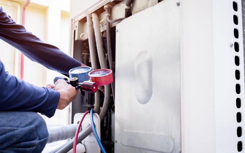 HVAC worker checks an air conditioning unit