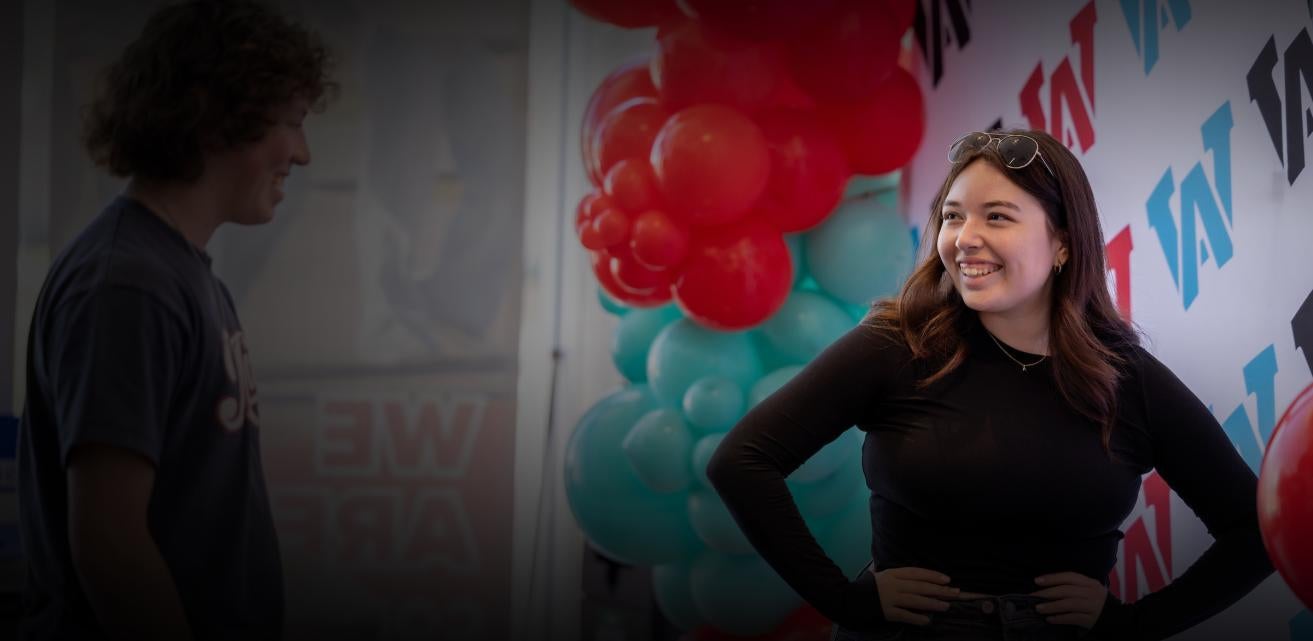 Two AWC students in front of AWC banner
